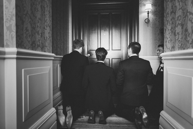 groom and best men performing wedding door games 