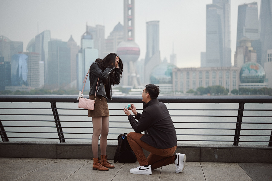 Bryan proposing to Hong Yun on one knee on Shanghai's Bund in the rain.