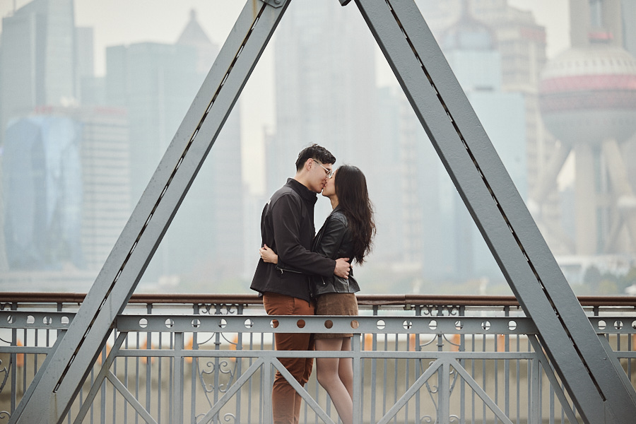 Newly engaged couple sharing a quiet moment after a surprise proposal on the Bund.